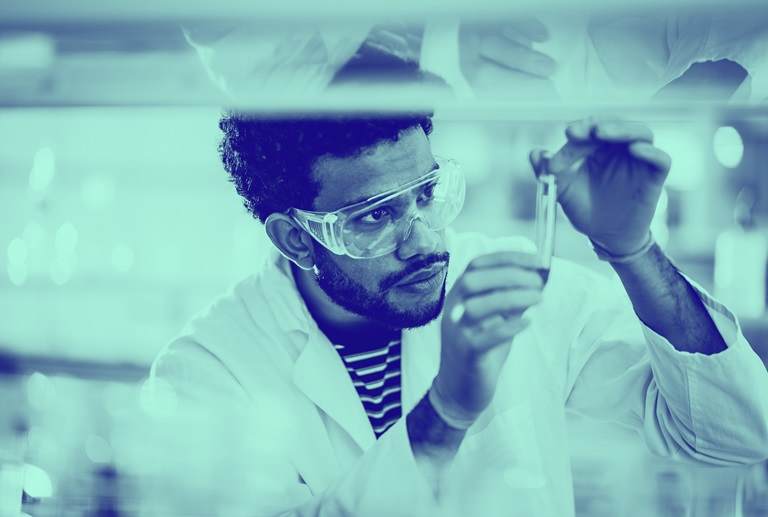 image of man in lab examining a vial