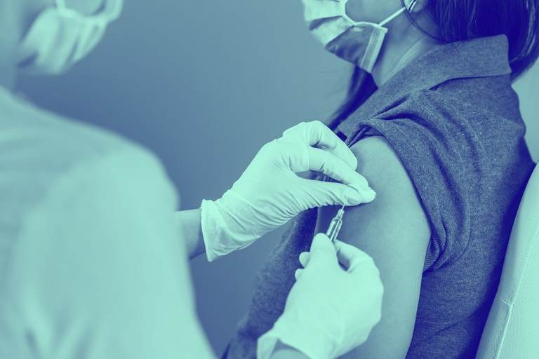 patient receiving vaccine with blue wash over image 