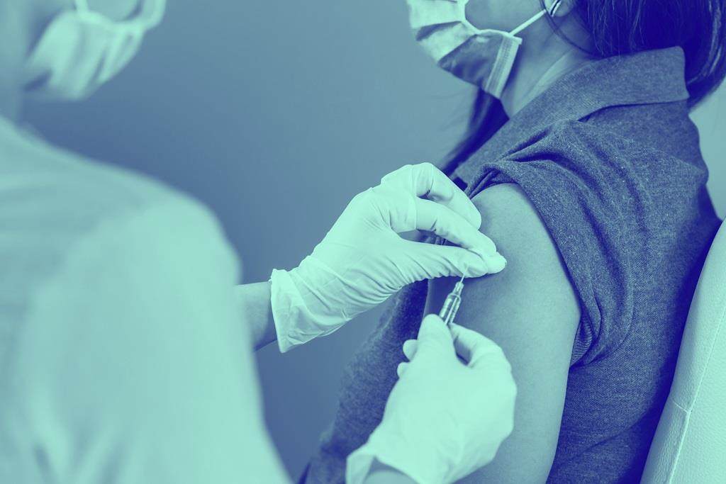 female receiving injection of vaccine
