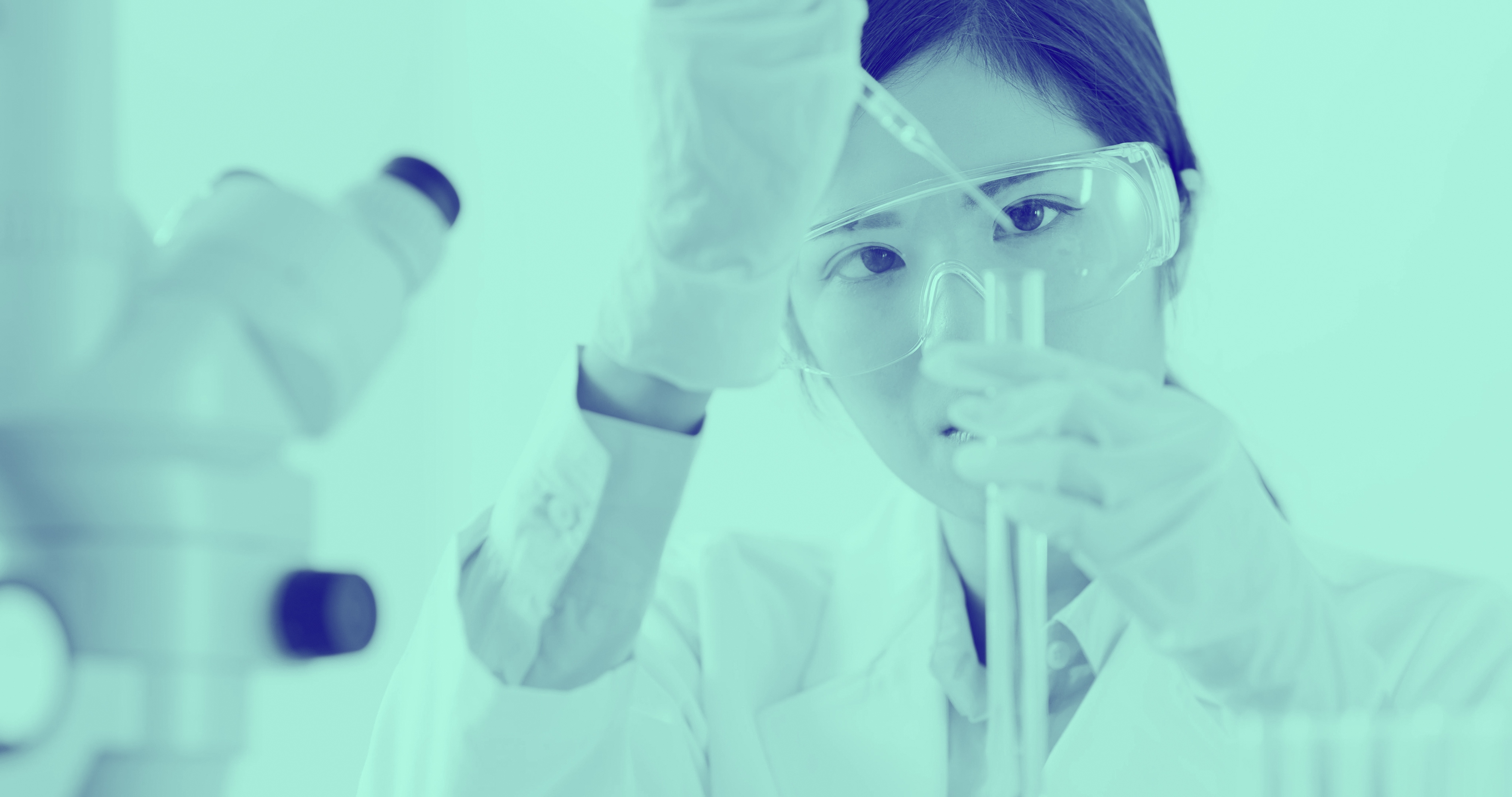 Woman in lab, looking at test tube