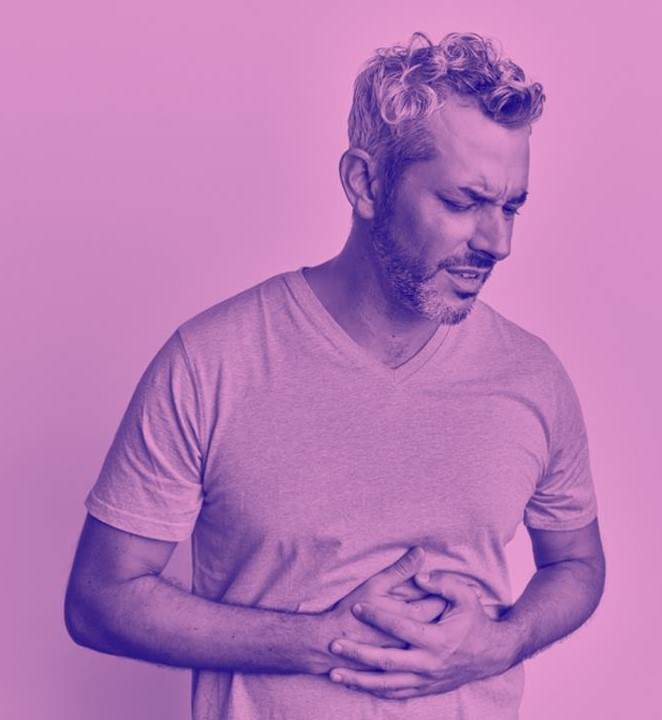 image of man grasping stomach in discomfort