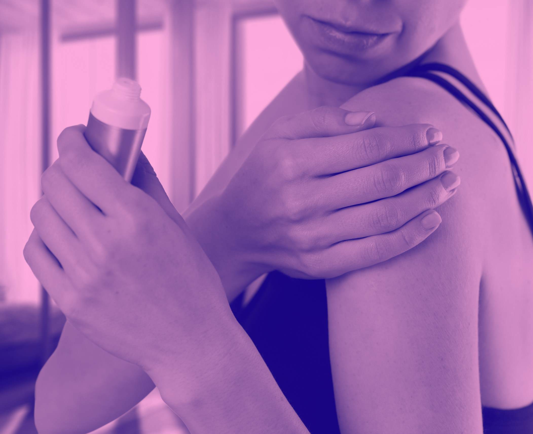 woman applying cream to upper arm and back