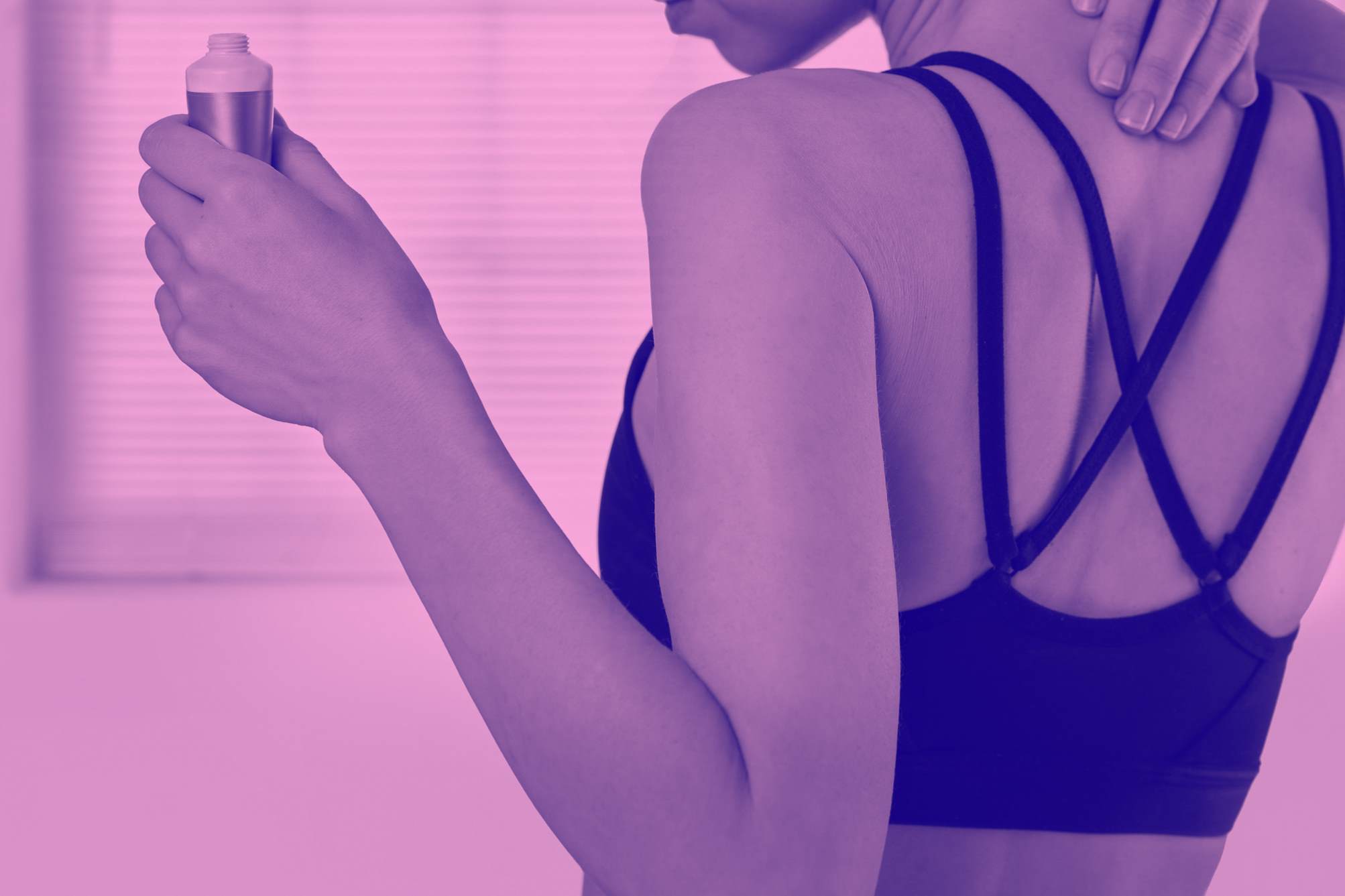 woman applying cream between shoulder blades