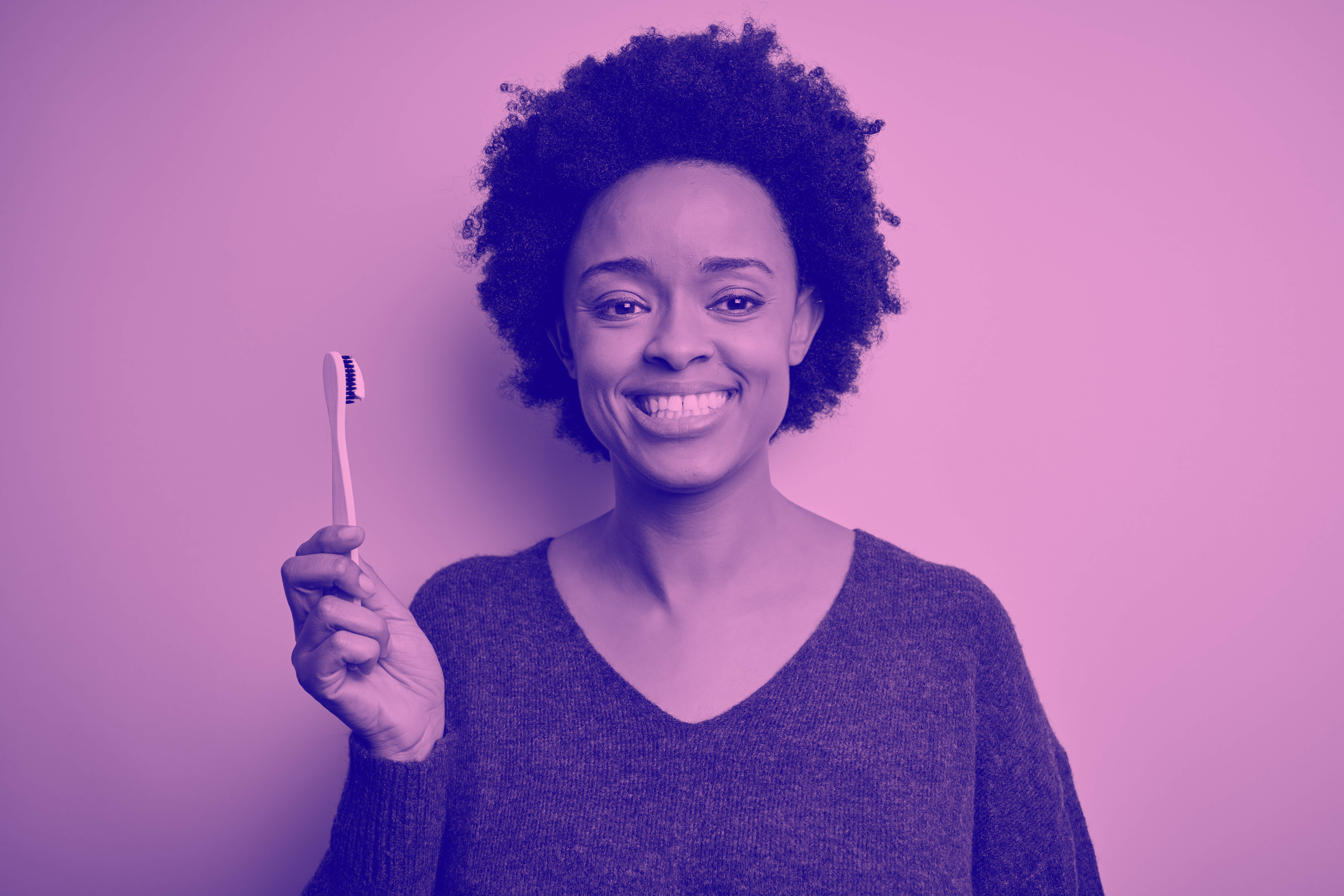 woman holding toothbrush with smile on her face