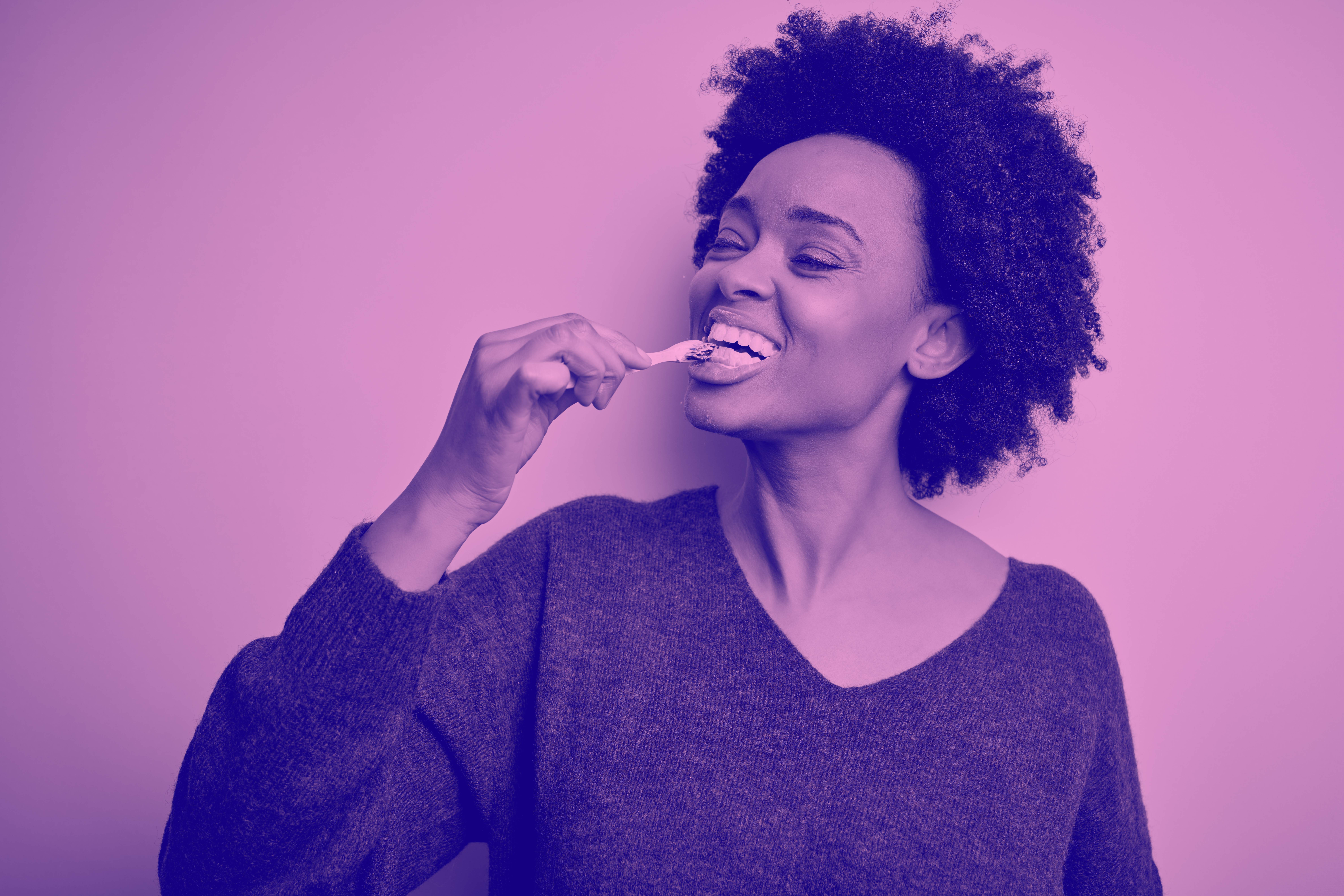 woman brushing her teeth happily
