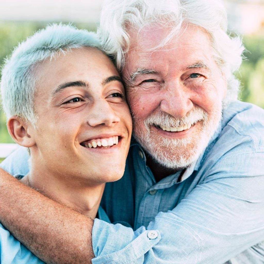 抱き合って微笑む二人の男性の画像