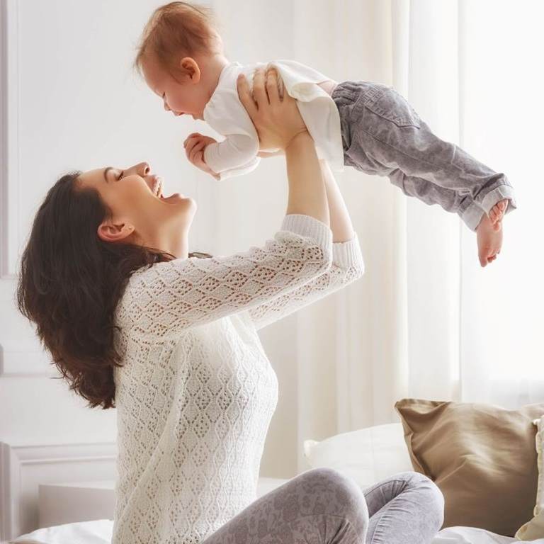image of woman lifting her baby up