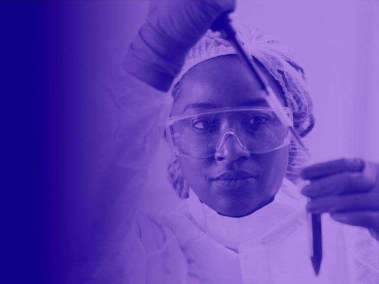 Image of croda employee in a lab looking into a test tube with a pippet