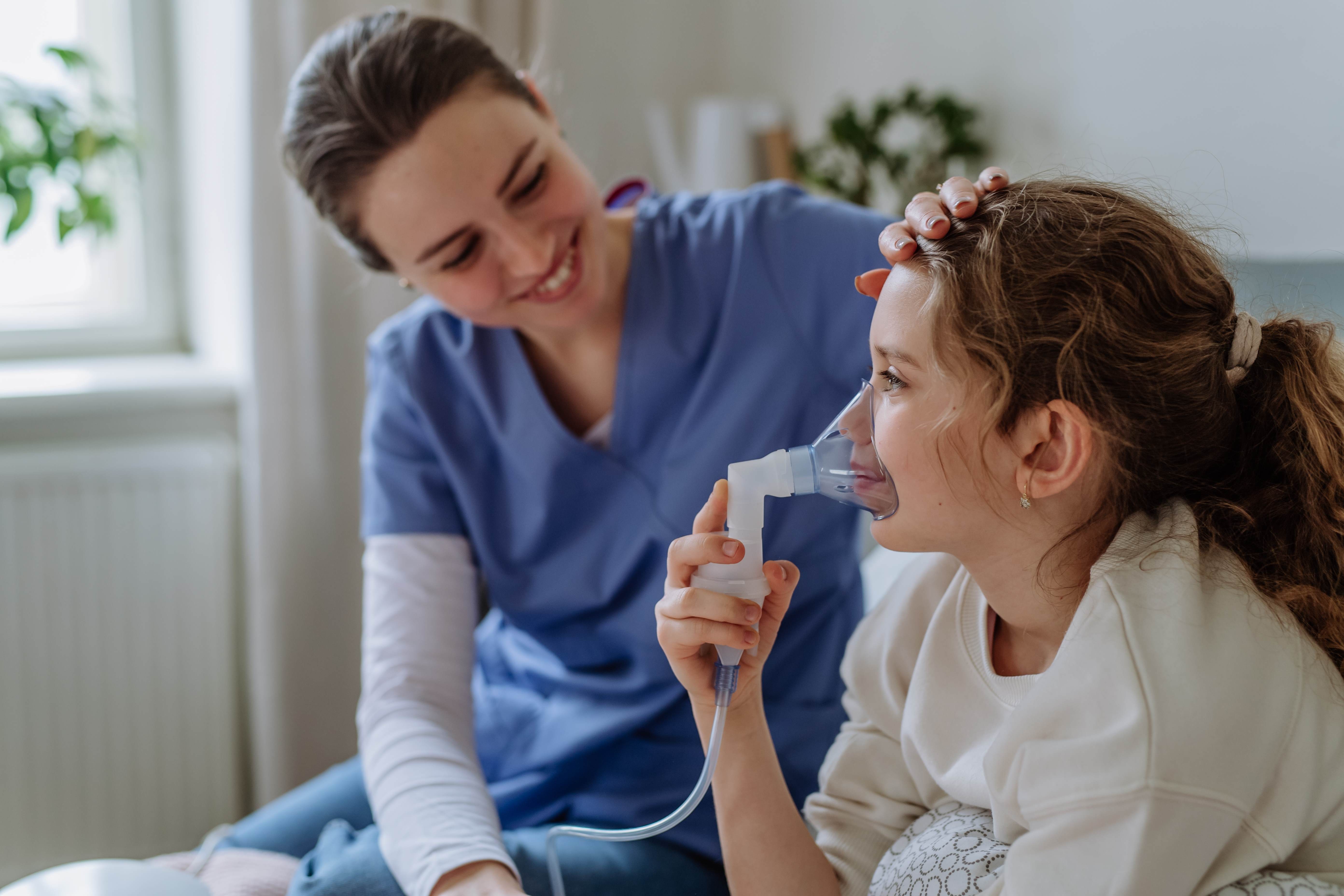 Nurse helping child with inhalation device