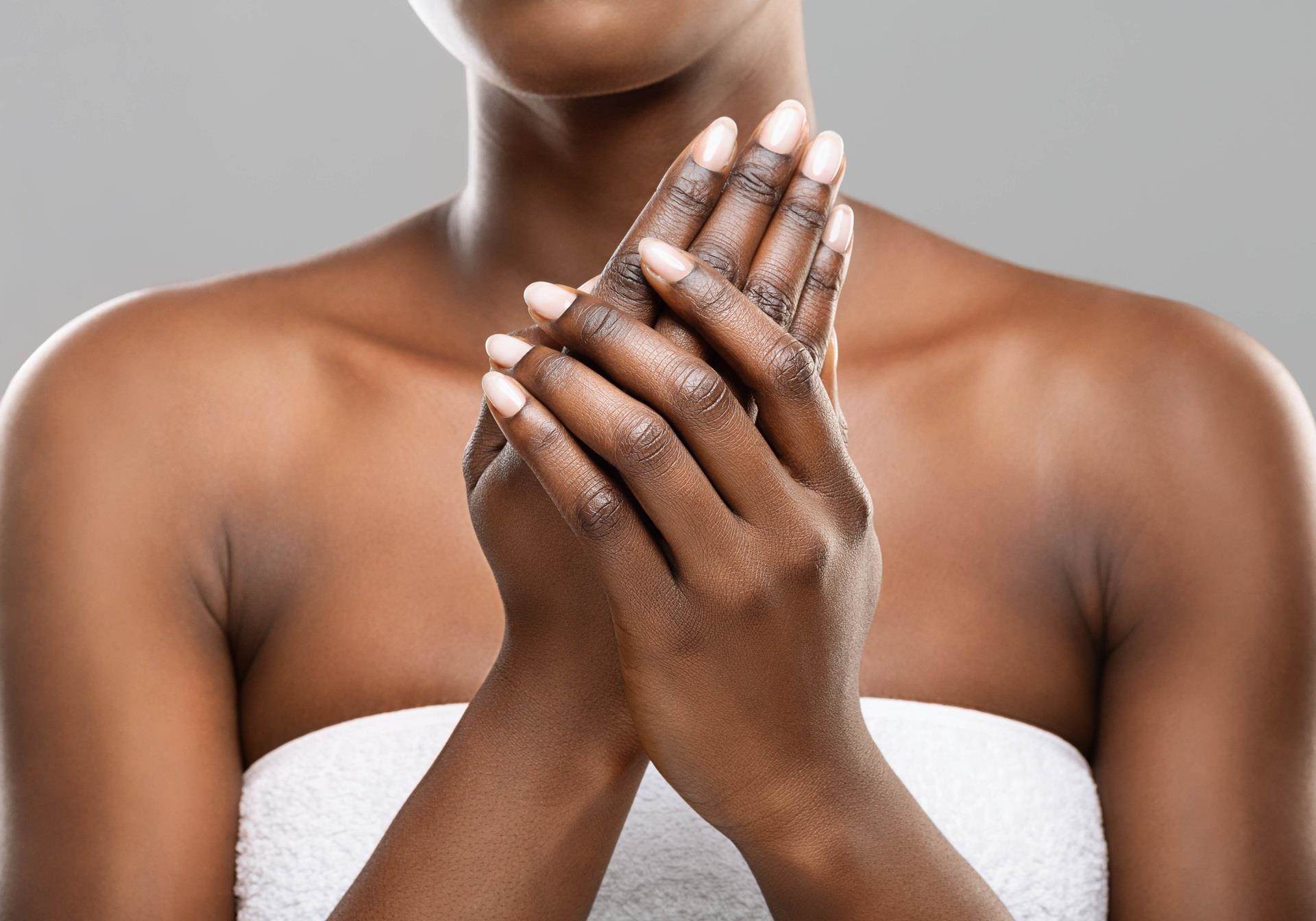 Mulher aplicando creme hidratante nas mãos