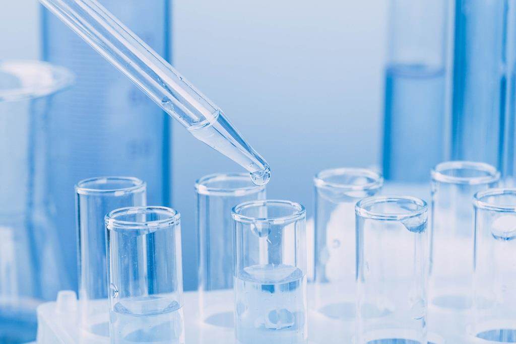 Laboratory glassware with a dropper dripping liquid into a test tube