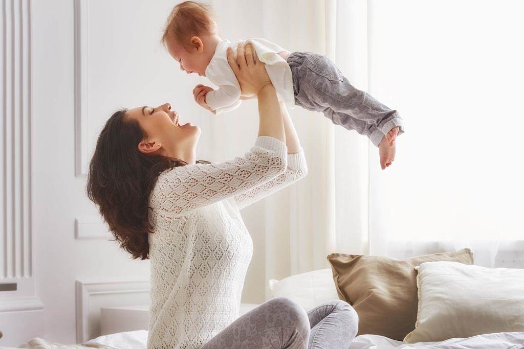 mother playing with her baby in the bedroom