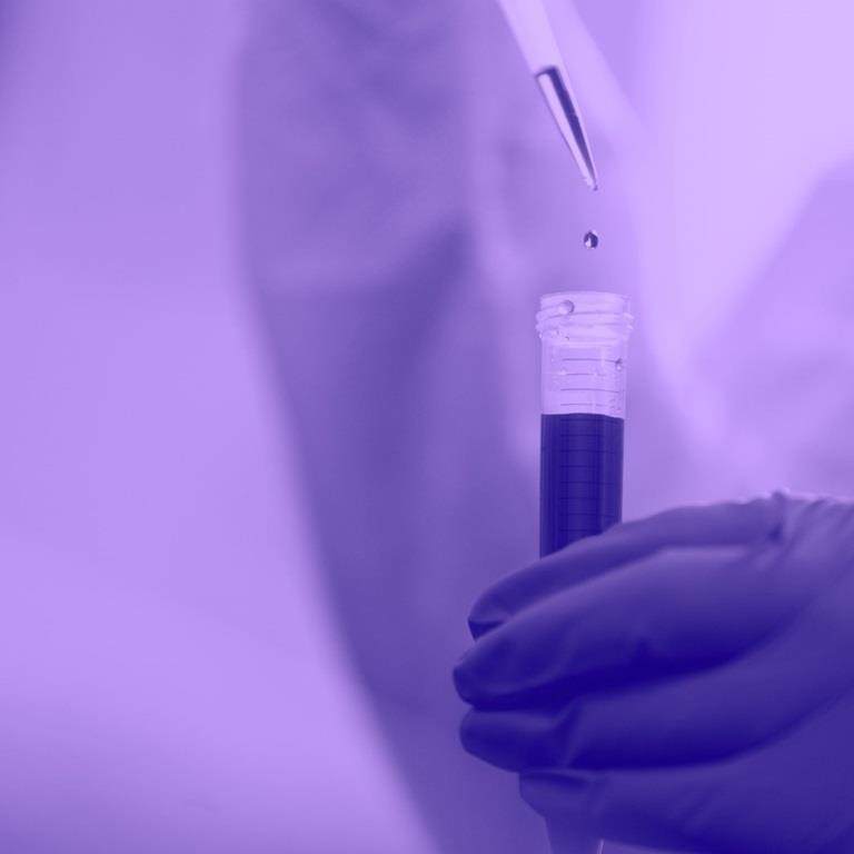 liquid being dropped into tube with purple wash over image